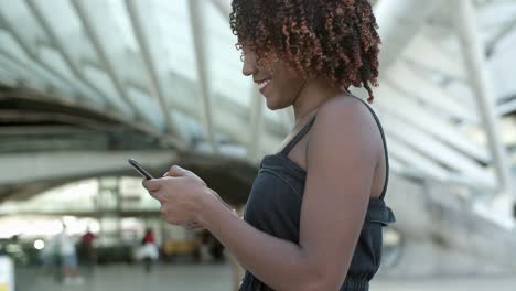 Seitenansicht-Einer-Jungen-Frau,-Die-Während-Eines-Spaziergangs-SMS-Auf-Dem-Smartphone-Schreibt